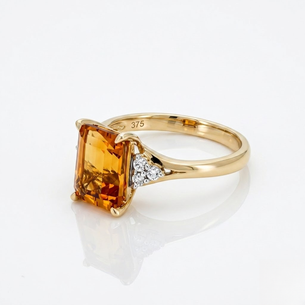 A yellow gold ring featuring a large rectangular orange citrine gemstone and a small cluster of clear diamonds on the band, shown on a reflective white surface.
