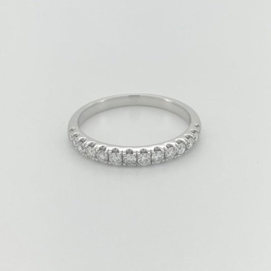 A thin white gold band ring with a row of small diamonds.