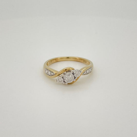 A yellow gold ring with a central round-cut diamond and small side diamonds.